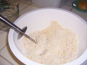 Using pastry blender to crumble together the shortening and flour